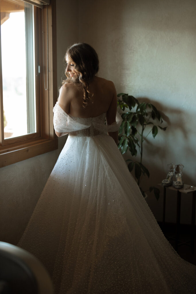 Bride putting on dress in bridal suite at Sycamore Farms. 