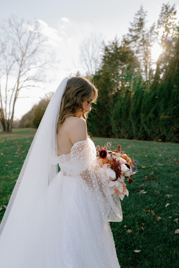 Bride looking down and admiring her bouquet.