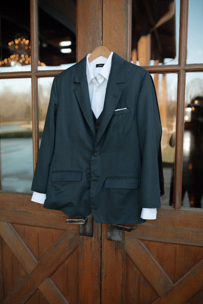 The groom's suit on a hanger on barn doors to capture details. 