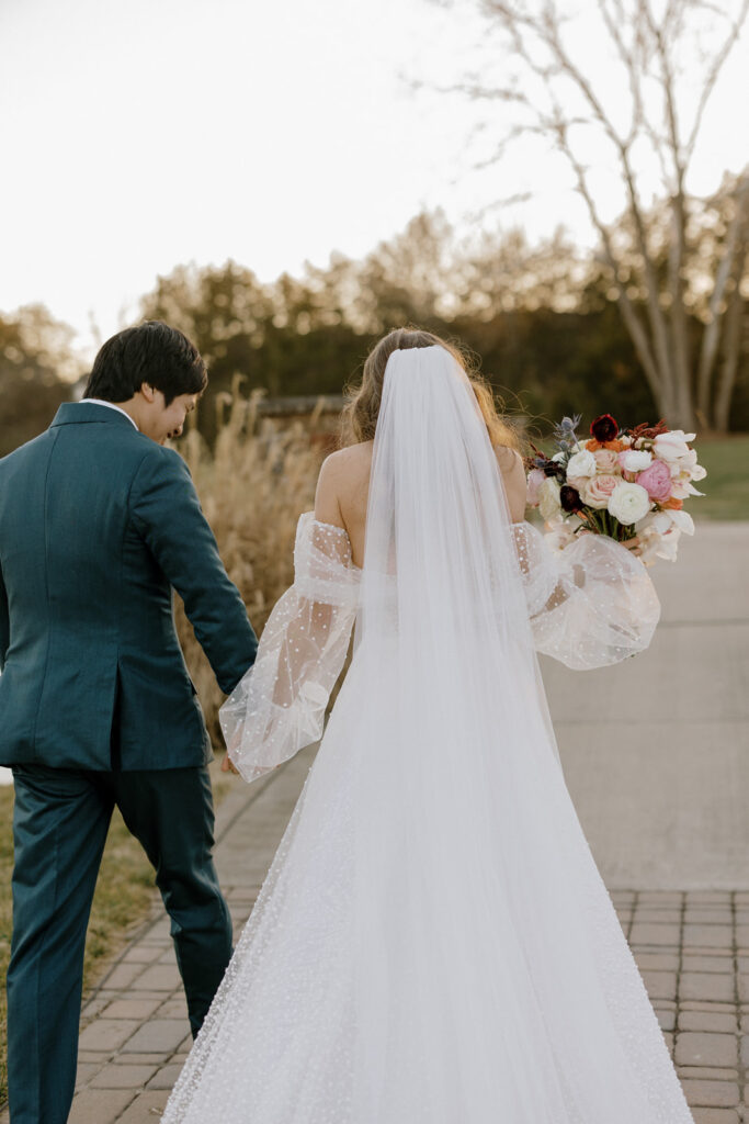 The bride and groom from behind walking back down the aisle after being married.