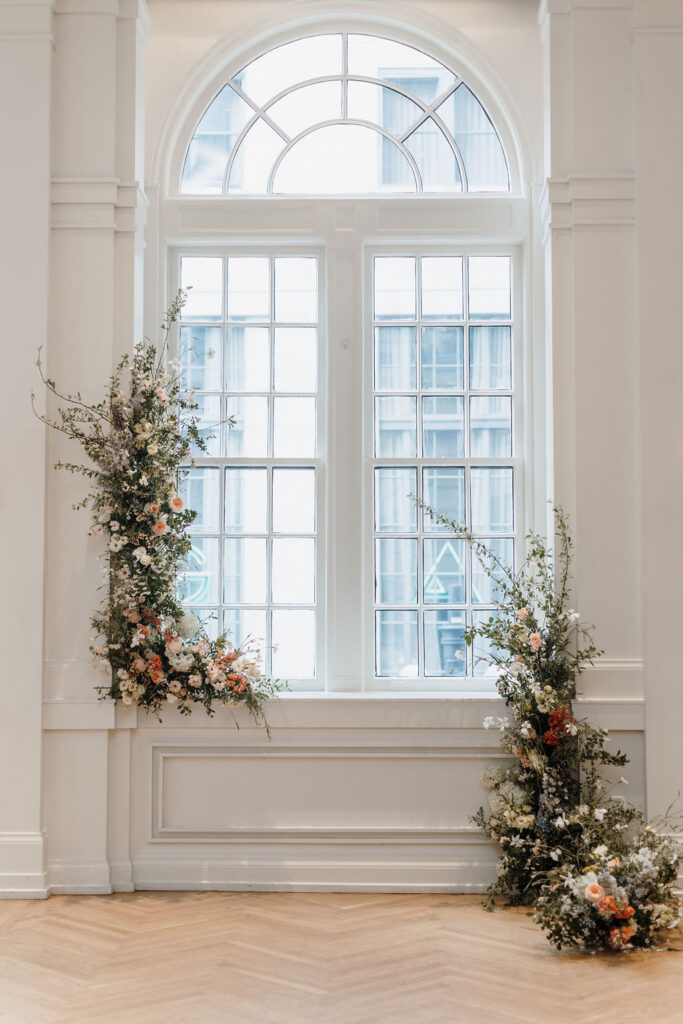 A wedding ceremony altar with two framing floral installations forming an arch