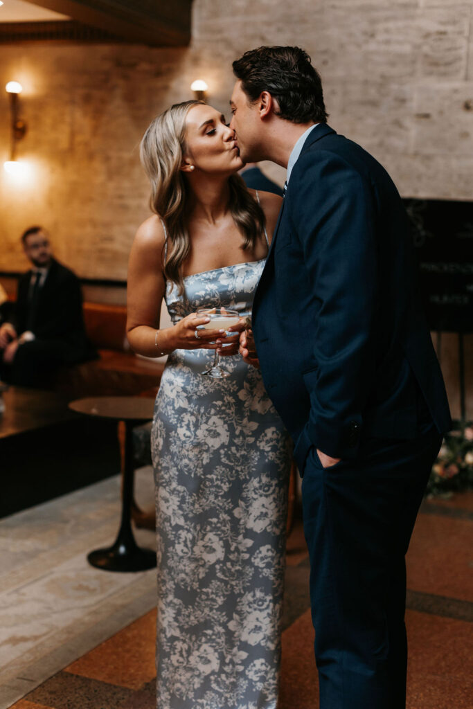 Two wedding guests lovingly share a kiss 