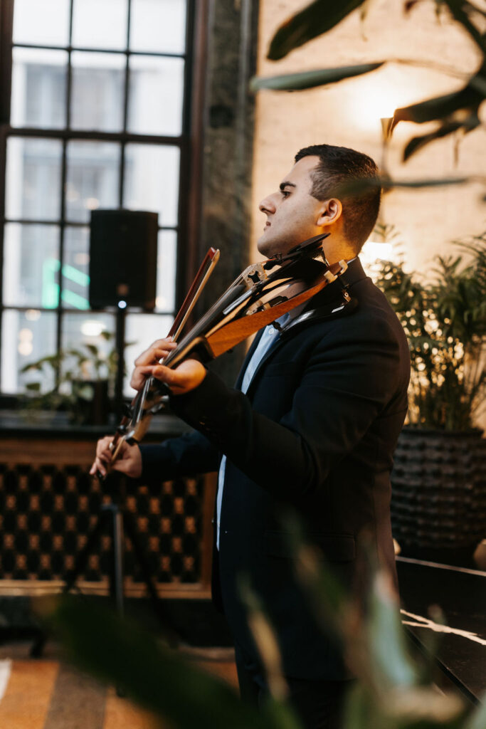 A violinist playing music wearing a black suit