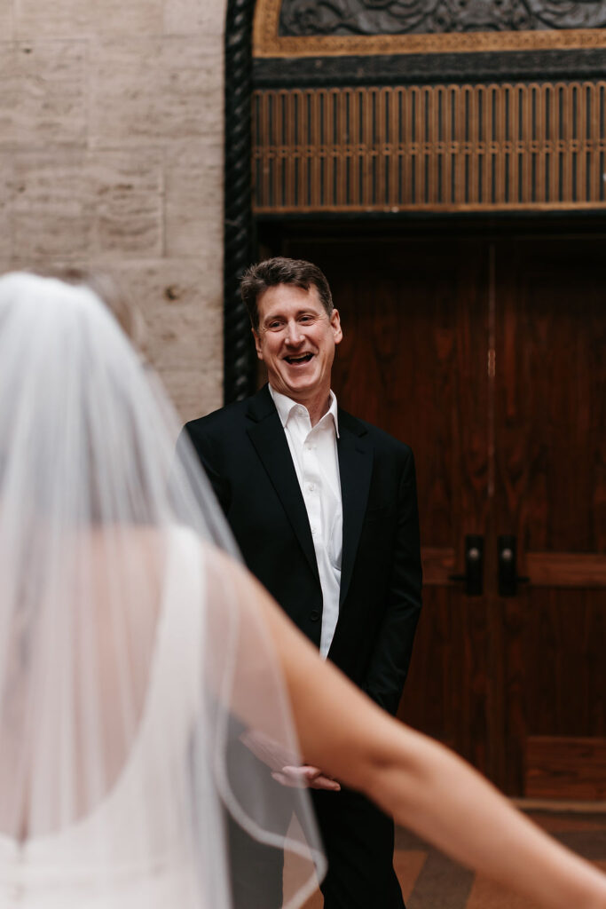 The father of the bride sees his daughter for the first time on her wedding day and has a big smile