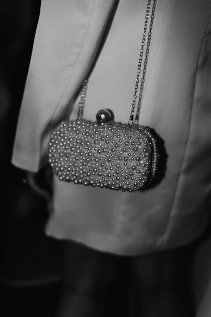 A detail photo of a pearl covered clutch with gold details in greyscale